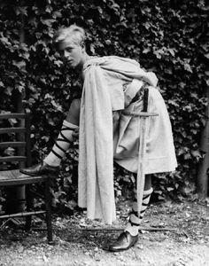 an old photo of a woman leaning on a chair