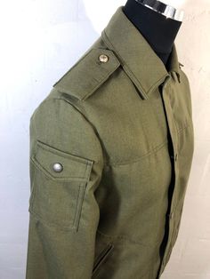 "Olive green blouson zipper & press stud poppers  elasticated waist  Size S  Pit to pit 40\" Shoulder to shoulder 18\" Shoulder to cuff 25\" Length 30\" Elastic waist ..see pics 3\" wide  Great condition  Interesting garment choose work wear & a military theme  Fully lined  2 external pockets  1 internal" Military Style Khaki Utility Jacket With Button Cuffs, Khaki Military Utility Jacket With Button Cuffs, Military Utility Jacket With Button Cuffs For Workwear, Military Style Utility Jacket With Button Cuffs For Work, Military Style Collared Outerwear With Buttons, Military Style Cotton Utility Jacket With Button Cuffs, Fitted Military Outerwear With Stand Collar, Fitted Military Outerwear With Pockets, Military Style Collared Utility Jacket With Buttons