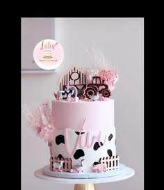 a pink and black cake on a white stand