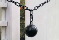 a black ball is hanging from a chain