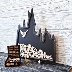 two pieces of paper cut out of the shape of a castle, and a book