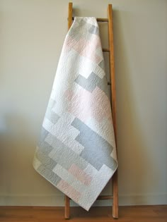 a towel is hanging up on a wooden rack in front of a gray and white wall