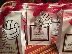 three bags with volleyball themed tags on them sitting on a table next to each other