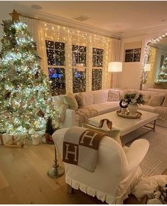 a living room filled with furniture and a christmas tree in front of a large window