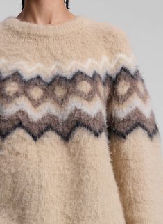 The Ezra Sweater is crafted from luxurious brushed alpaca in dark taupe with a traditional Fair Isle pattern, showcasing artisanal craftsmanship. This relaxed silhouette features a high, rounded neckline with intricate ribbed detailing at the neck, hem, and cuffs, adding subtle texture to the cozy knit. Shop Sweaters. Styling Tip: Pair with pleated trousers for a polished, winter-ready look. Shop Sweaters, Fall Fashion Sweaters, Maxi Jumpsuit, Dark Taupe, Fair Isle Pattern, Favorite Daughter, Pleated Trousers, Fair Isle Sweater, Cozy Knit