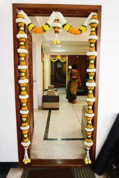 a mirror with flowers and garlands on the wall in front of it that is decorated