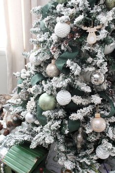 a white christmas tree with green and silver ornaments