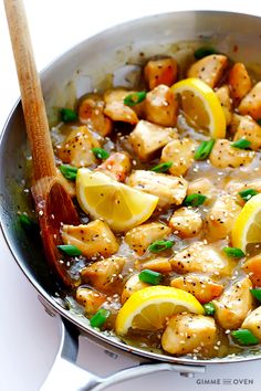 a skillet filled with chicken and lemons on top of a white countertop