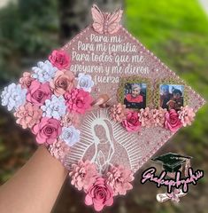 a hand holding a pink and white graduation cap with flowers on the front, and two photos in the center