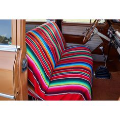 the interior of an old car with a colorful seat cover