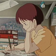 a person sitting at a desk with books and a pen