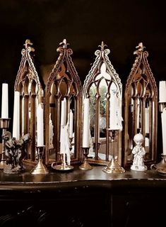 an assortment of candles and figurines sitting on a table in front of a mirror