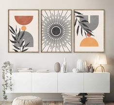 two art prints on the wall above a white sideboard in a modern living room