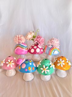 a group of colorful mushrooms with flowers in them