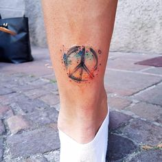 a person with a peace sign tattoo on their leg