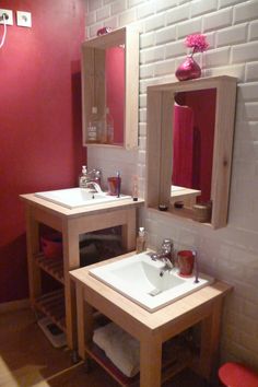 a bathroom with two sinks and a mirror on the wall next to a red stool