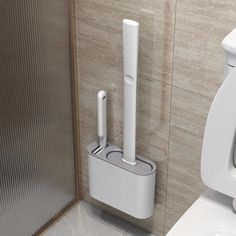 a white toilet sitting next to a urinal in a tiled bathroom with gray walls