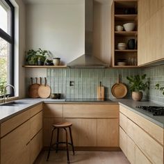 a kitchen with wooden cabinets and green tile backsplash, potted plants on the counter