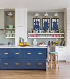 a kitchen with blue cabinets and yellow stools in front of the counter top is an island