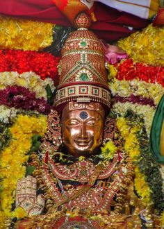 the statue is surrounded by flowers and garlands