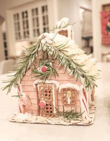 a gingerbread house decorated with icing and greenery on a kitchen countertop