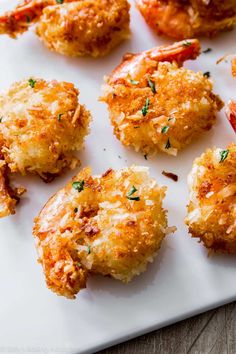 several crab cakes on a white plate with parsley sprinkled on the top