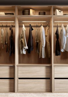 a wooden closet with clothes hanging on it