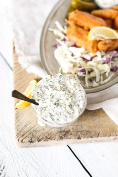 fish and coleslaw on a plate with a side of pickle wedges