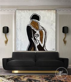 a living room with a black couch and painting on the wall in it's center