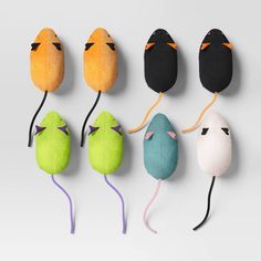 five different colored mouses are lined up in the shape of small mice, one with eyes