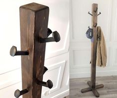 a coat rack made out of wood with two coats hanging from it's sides