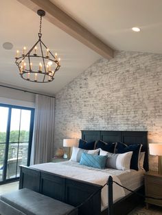 a bedroom with a large bed and a chandelier hanging from it's ceiling