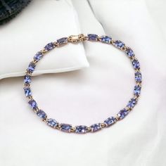 Indulge in the allure of timeless glamour with our Handmade Tanzanite Stone Tennis Cushion Cut Bracelet, a masterpiece of elegance meticulously crafted in 925 sterling silver.  Our artisans, with their unwavering commitment to excellence, have meticulously designed this bracelet to be a true work of art. The 925 sterling silver setting, enhanced by gold rhodium plating , reflects a perfect blend of classic and contemporary design. Cushion Tanzanite, with its captivating violet-blue shades, is renowned for its unique and mesmerizing color. Tanzanite is believed to have spiritual properties, promoting calmness and enhancing communication. Tanzanite is exclusively found in Tanzania, making it a rare and precious gem. The geographical uniqueness imparts a distinct character to each stone, ensu Formal Blue Tanzanite Bracelets, Fine Jewelry Tanzanite Bracelets For Gift, Tanzanite Bracelet, Timeless Glamour, Bracelet For Her, Art Deco Bracelet, Tanzanite Stone, Blue Tanzanite, Precious Gems