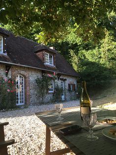 a bottle of wine sitting on top of a table in front of a brick building