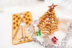 two wooden christmas tree ornaments sitting next to each other