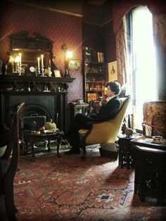 a man sitting in a chair next to a fire place