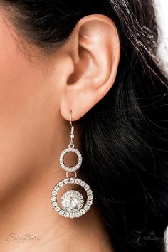 a close up of a woman's ear wearing large earrings with round and circle design