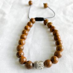 Wood Buddha Unisex Bracelet Symbolic Adjustable Rectangular Jewelry, Casual Rectangular Jewelry For Gift, Nickel-free Brown Bracelets As Gift, Nickel-free Brown Bracelets For Gifts, Casual Brown Jewelry As Gift, Adjustable Holistic Brown Jewelry, Spiritual Adjustable Bracelets For Everyday, Adjustable Brown Bracelet For Meditation, Adjustable Silver Jewelry With Wooden Beads