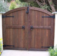 a large wooden gate with metal hardware on it's sides and two doors open