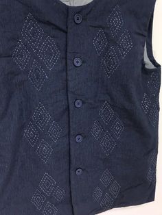 a black vest with white and blue designs on it