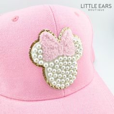 a pink baseball cap with a minnie mouse sequin patch on the front and side