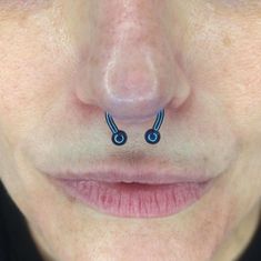 a woman's nose with two piercings on it