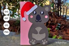 a paper cut out of a koala wearing a santa hat