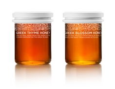 two jars of greek thye honey on a white background