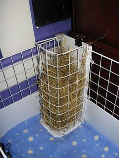 a pile of hay sitting in the corner of a room next to a window with blue and white walls