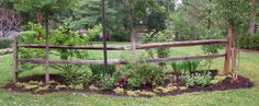 a wooden fence surrounded by flowers and trees