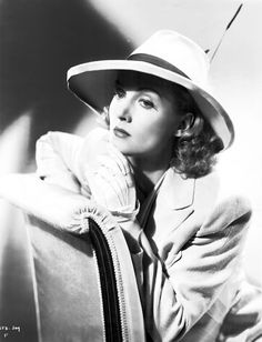 black and white photograph of a woman wearing a hat with her hand on her shoulder