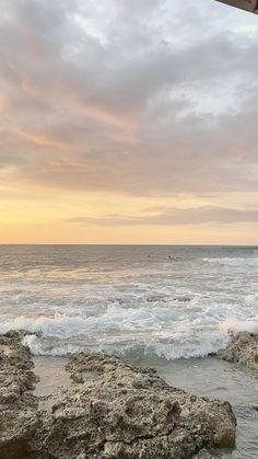 an ocean view with waves crashing on the rocks