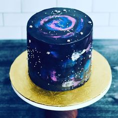 there is a cake that has been decorated with stars and galaxy designs on the top