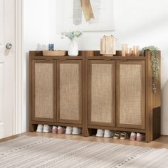 a wooden cabinet with two doors and shoes on it next to a rug in a room